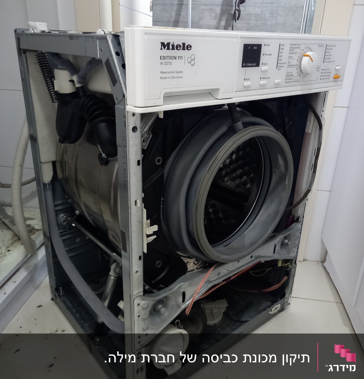 מכונת כביסה פתוחה עם חלקים פנימיים חשופים
